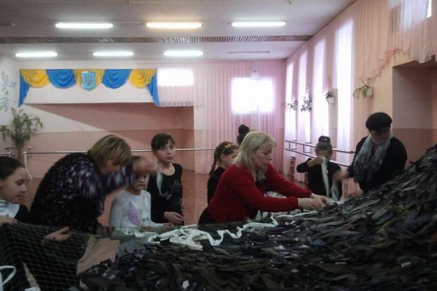 Вихованці зразкового танцювального колективу "Веселі Гуцулята" плетуть маскувальні сітки для української армії