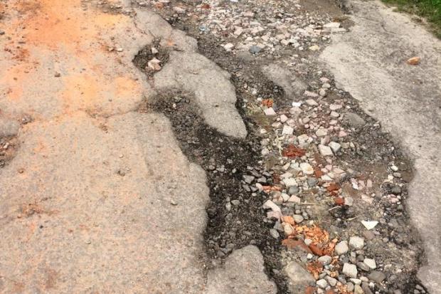 Жителі вулиці Шухевича систематично латають дорогу камінням, кусками цегли, бетону та іншими будівельними відходами | Фо