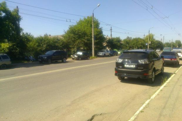 Пішохідний перехід знаходиться між двома зупинками громадського транспорту, де водії облаштували собі автомобільні стоян