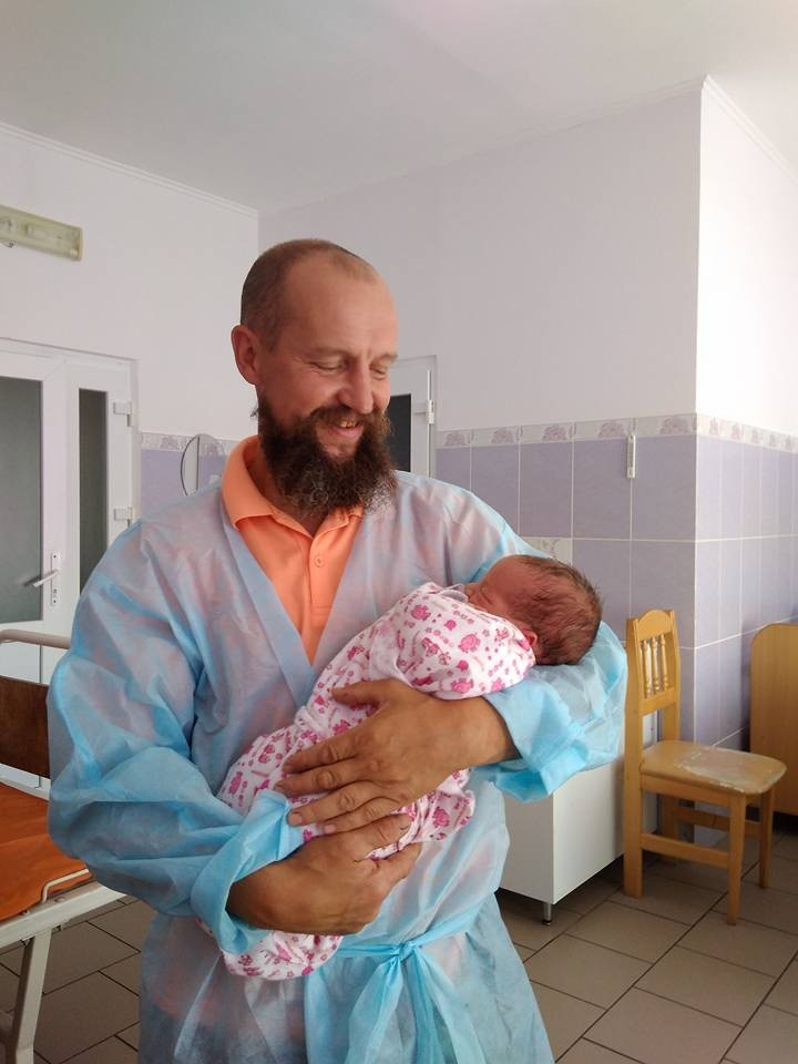 Олег Бутусін тримає на руках донечку &mdash; 12-ту дитину у родині