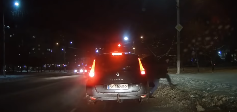 На перехресті  злодій швидко підбігає, відчиняє дверцята, забирає сумку з переднього сидіння і втікає