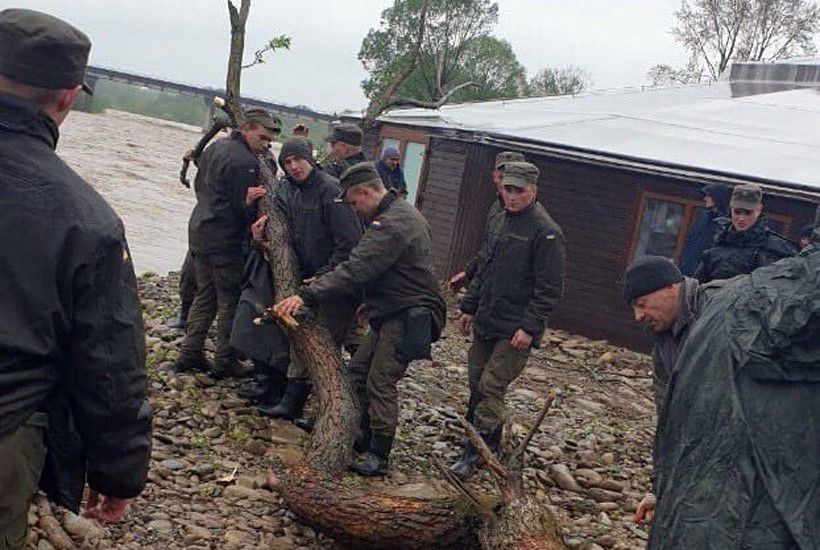 Нацгвардійці допомагають не поплисти в річку місцевій колибі