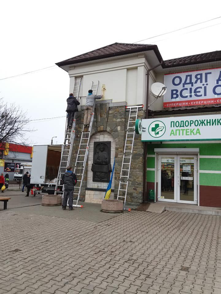 Чоловіки зняли прапор, який був прикріплений на будинку, та намагалися замінити його рекламою | Фото: Ольга Еланіна