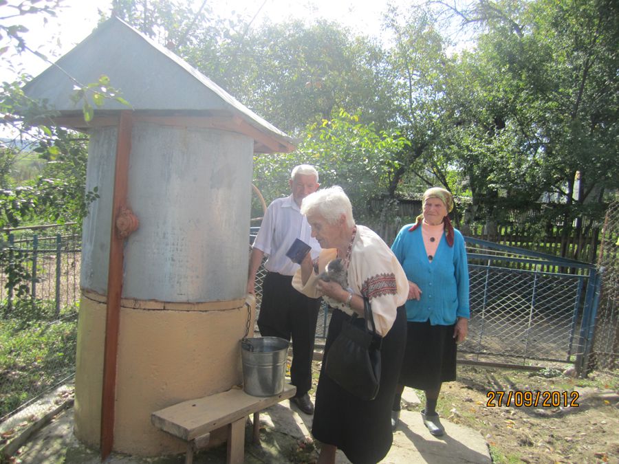 Віра Дякон коло криниці на подвір'ї, де народилася. Петранка, 27 вересня 2012 року