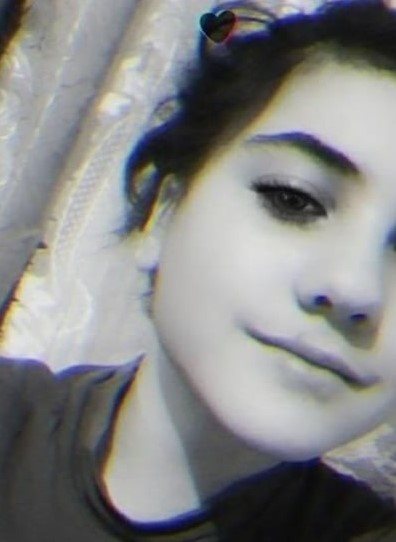 Дівчинка була одягнута в сині джинси зі смугами на боках, чорне кашемірове пальто, чорно-білі кеди