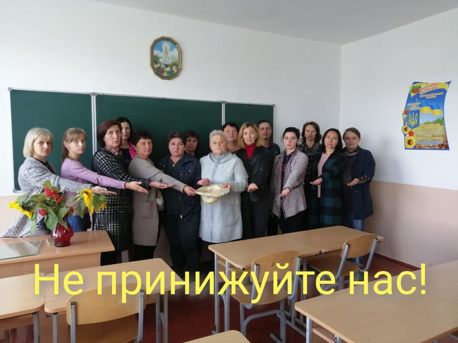 На сторінці Рахинянської гімназії у Фейсбуці виставили фото, де вчителі стоять з простягнутими руками