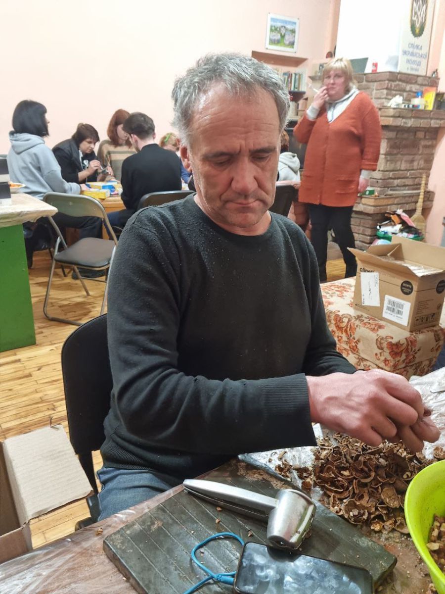 Горіхи чистить Петро Кузів, який 32 роки є членом Спілки української молоді. Фото: Міська рада
