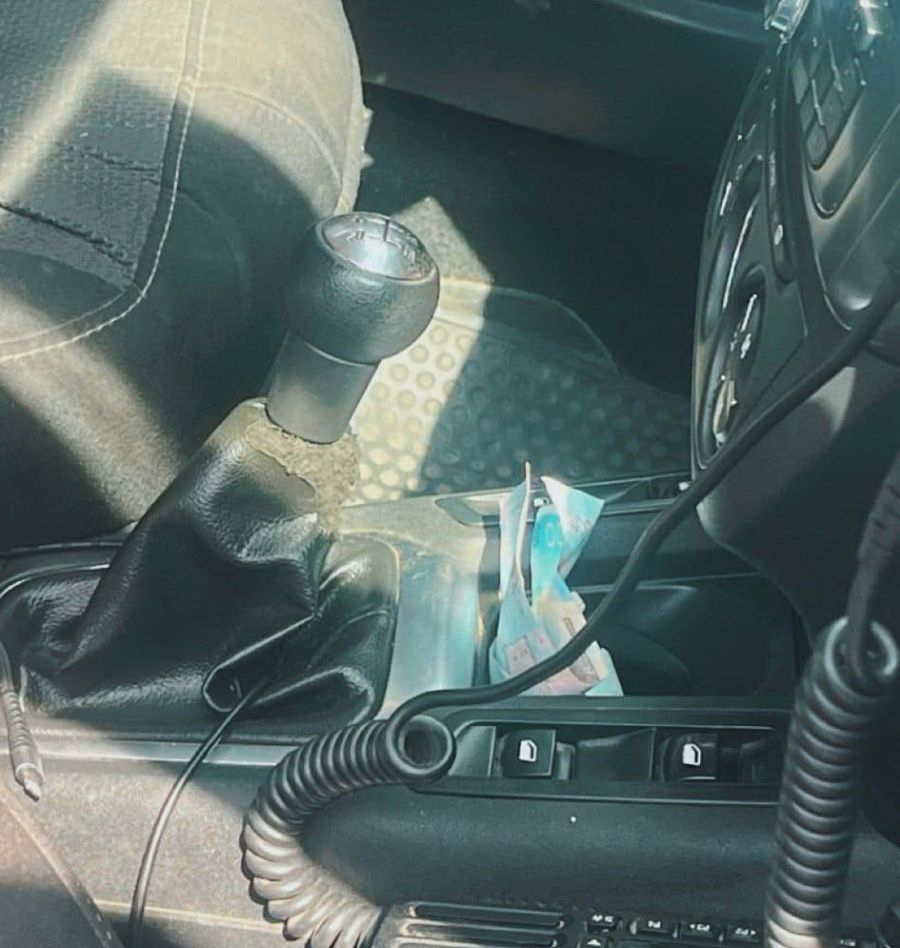 Чоловік поклав гроші до службового автомобіля.