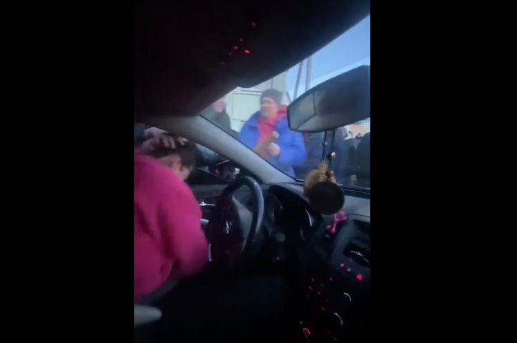 Жінку силоміць намагалися витягнути із автомобіля. Фото: скрін із відео