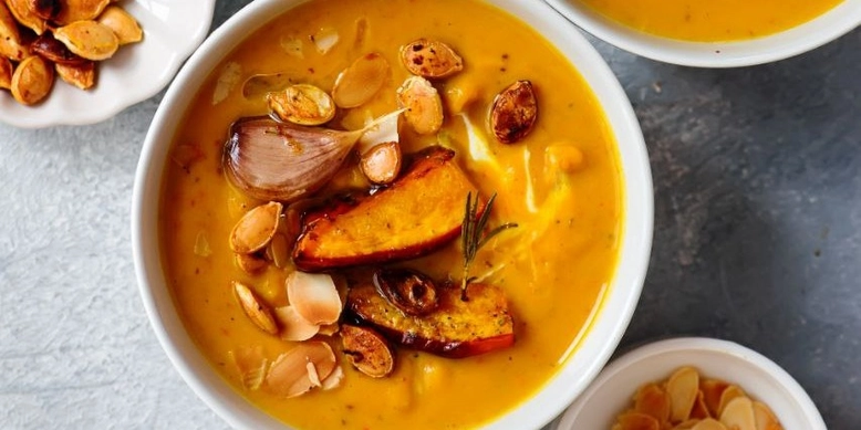 Приготовлений суп подавати з йогуртом, травами, насінням і мигдалем