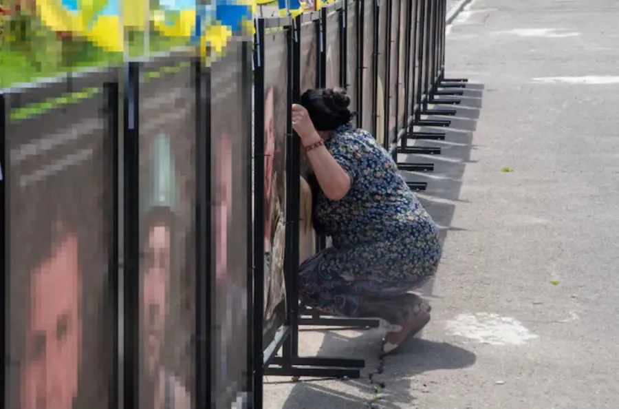 Мама на колінах біля світлини свого сина на "Алеї віри та надії" у Калуші. Фото: Didier Verbaere