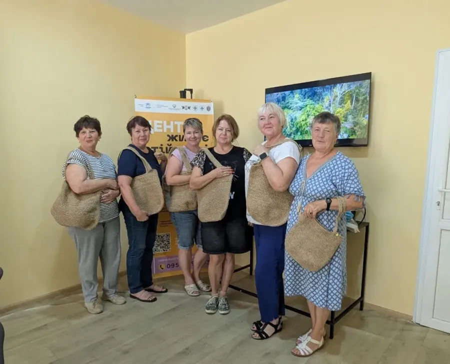 Учасниці майстеркласу тримають в руках створені джутові сумки