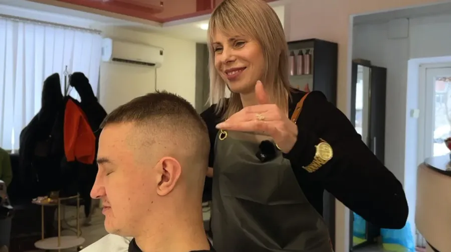 Надія Яців стриже захисника Миколу Іващенка, якому ампутували праву руку