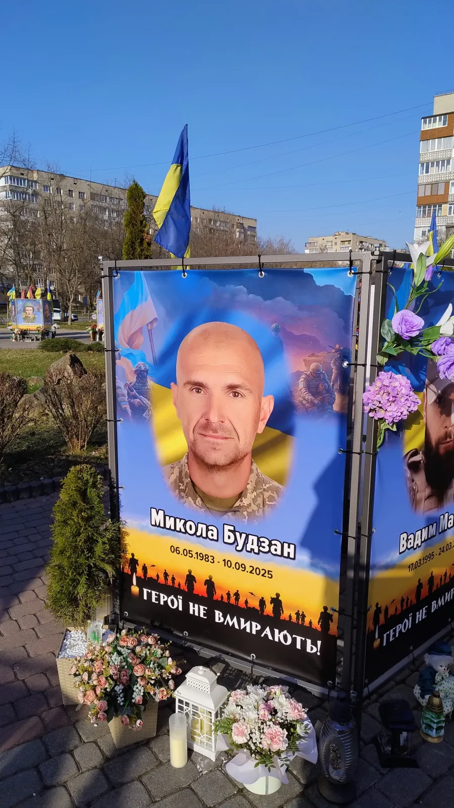 Родина подарує рослини для клумби, що поряд з банером Миколи Будзана на Алеї Героїв